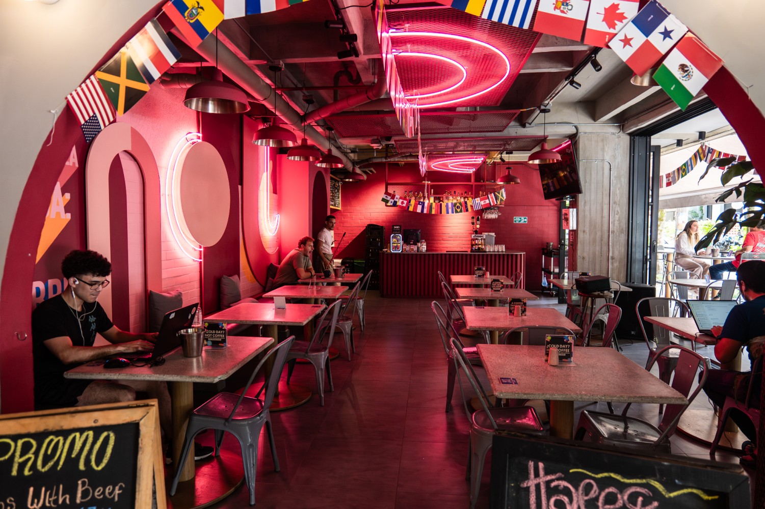 A dining area with red walls and neon signs