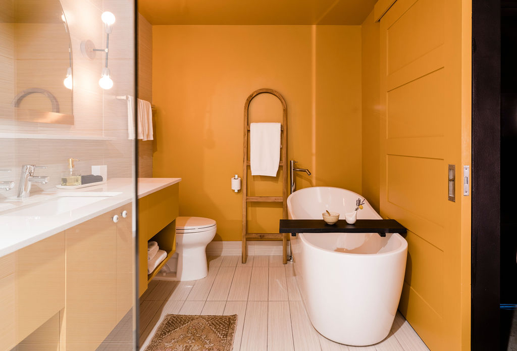 A modern bathroom with a freestanding tub, double vanity, and glass-enclosed shower.